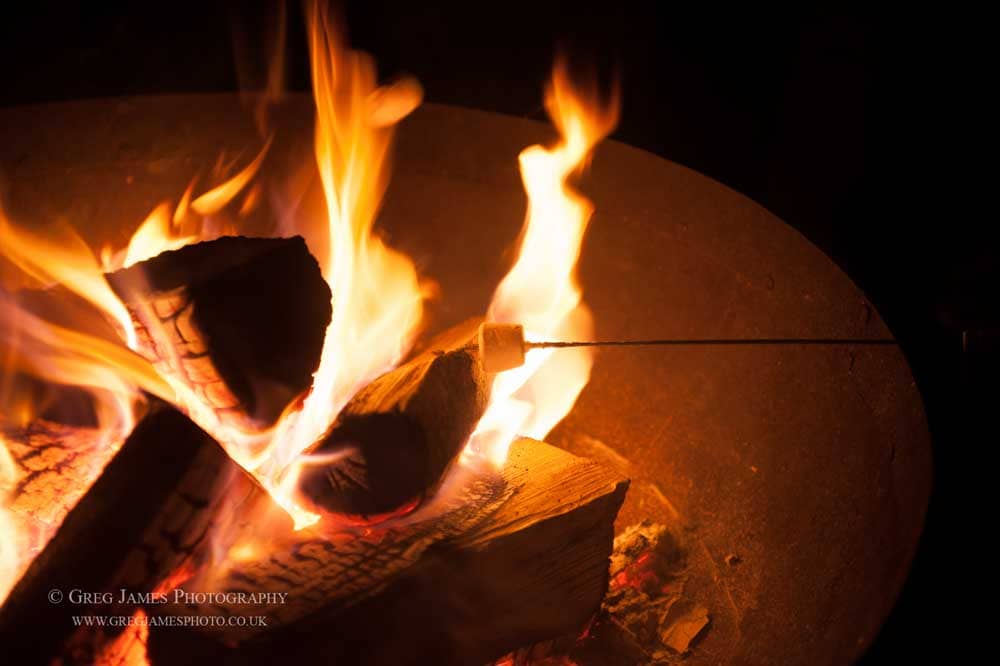 Image of marshmallow being toasted in a large fire-pit