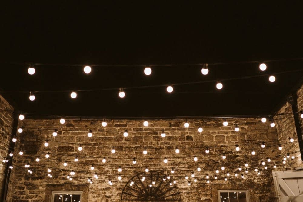 Under the night sky, Pennard House transforms into a captivating space with a festoon zig-zag lighting canopy. The enchanting lights create a graceful pattern against the dark expanse, adding a touch of elegance and magic to the wedding celebration.