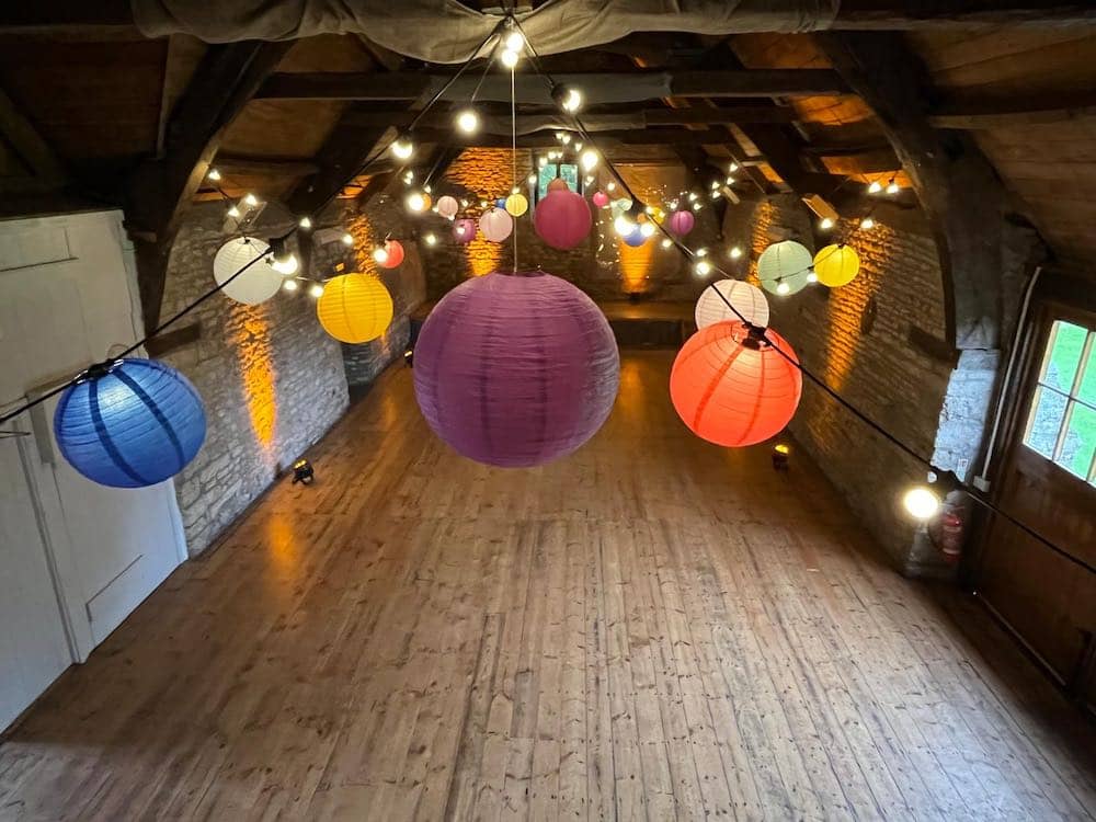 Mells Barn Somerset with festoon lighting and shades of many colours attached.