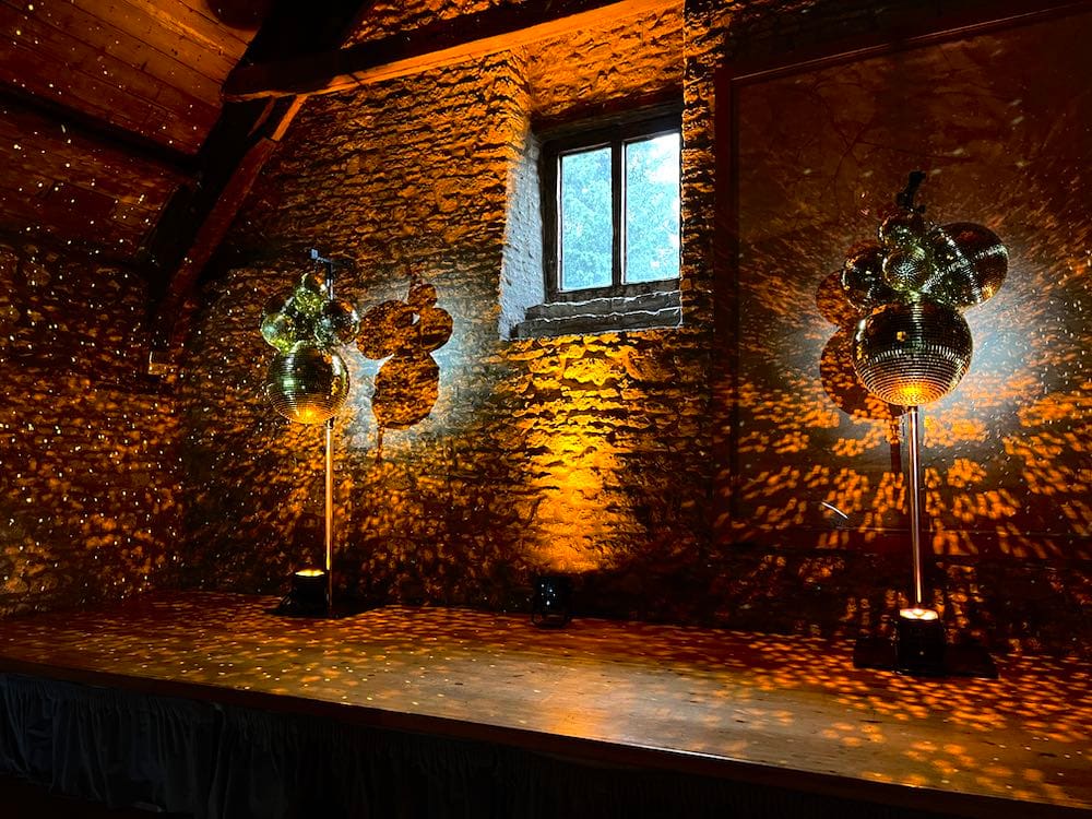 Mirrorball clusters either side of a stage with beautiful reflected light.