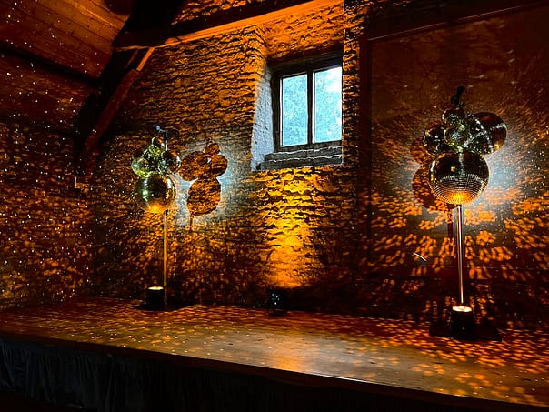 Mirror-ball clusters either side of a stage with beautiful reflected light.