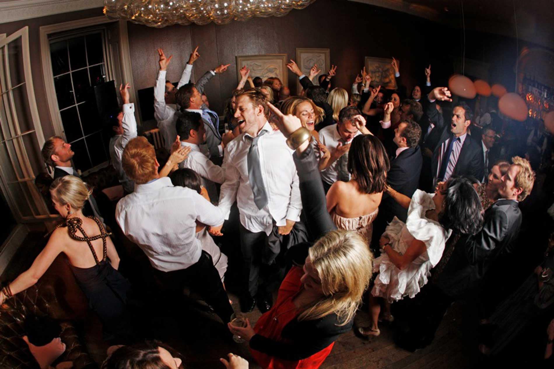 Image of a packed dance-floor with wedding guests enjoying themsleves