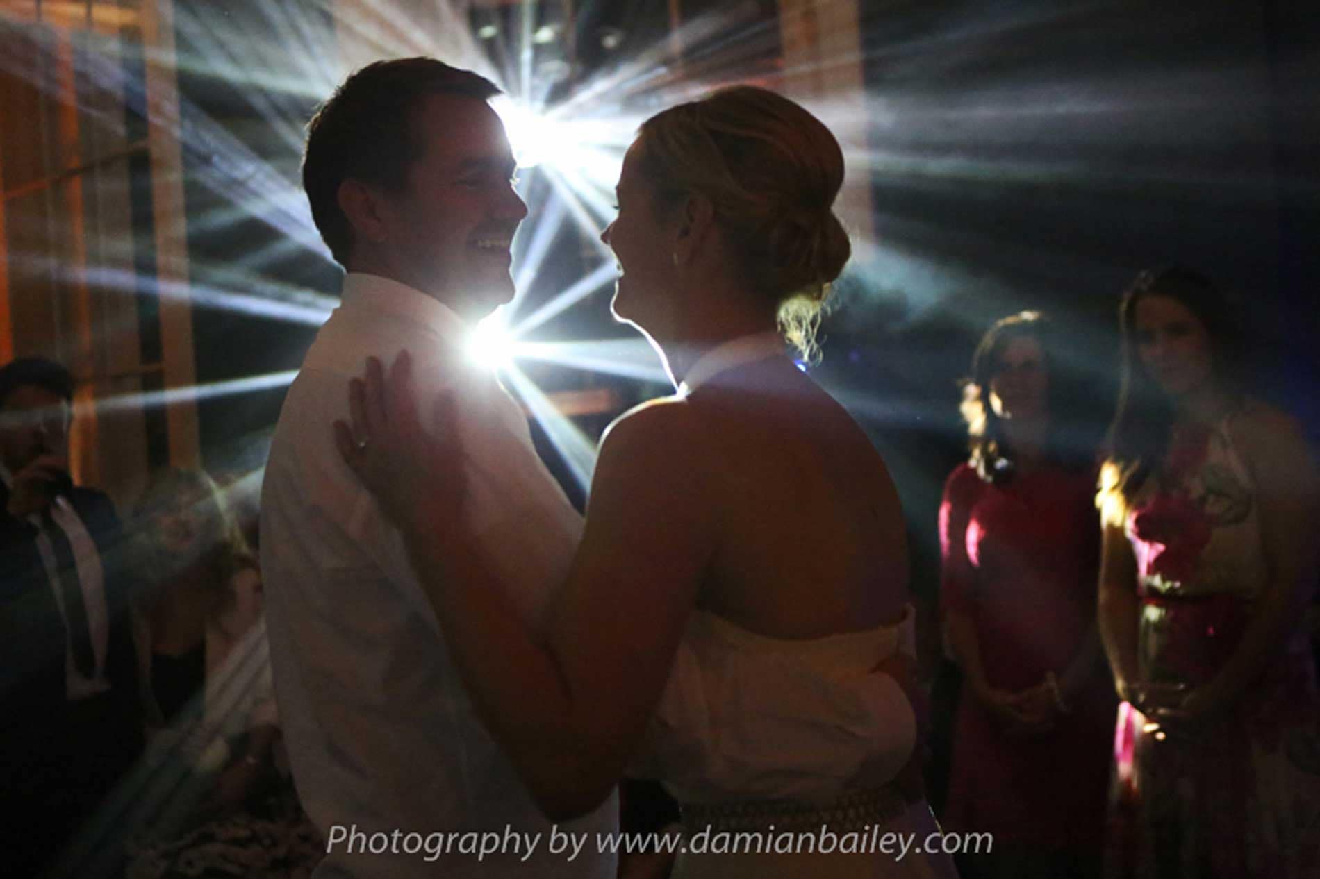 Image of a first dance with bride and groom and dj lighting.